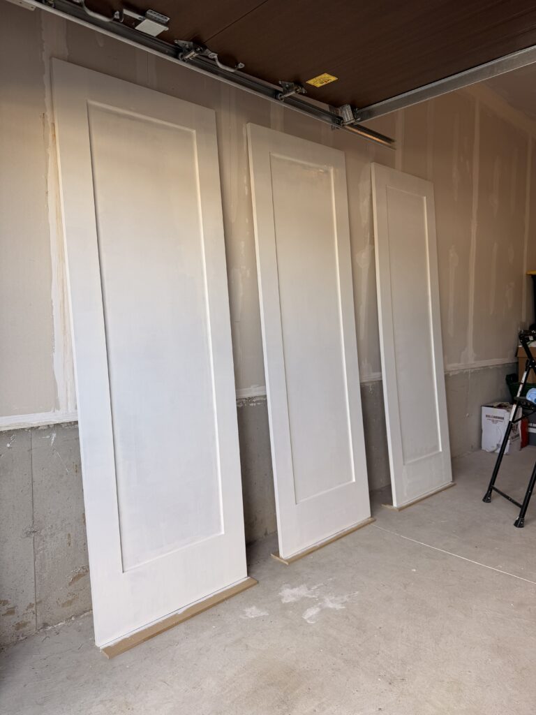 the finish carpenter priming the custom closet doors in Hamilton